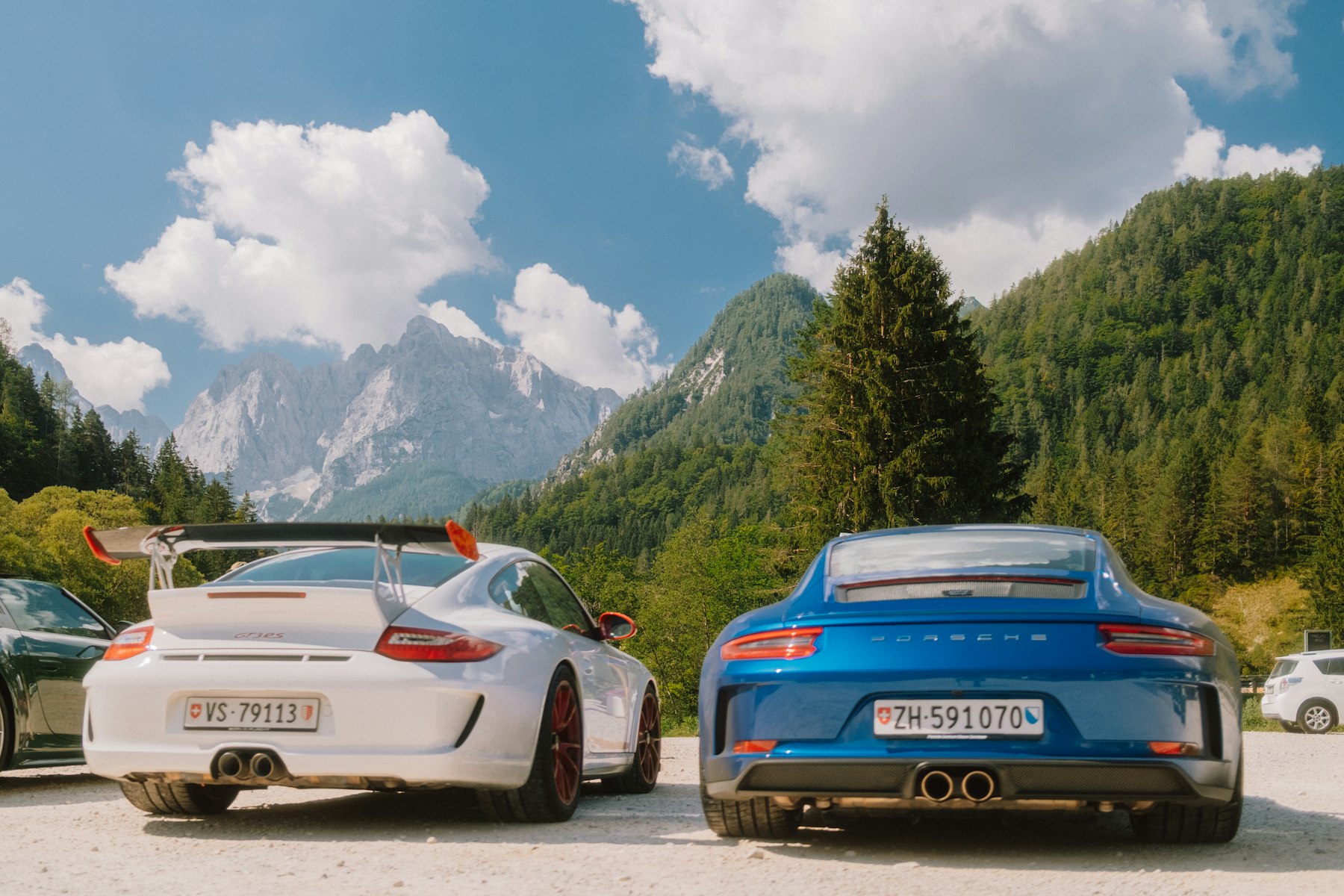 Porsche GT3 und weitere Sportwagen vor Bergkulisse